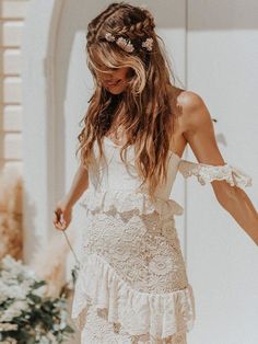 a woman in a white dress is walking down the street with her hand on her hip