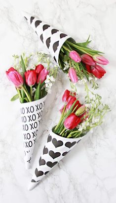 two vases filled with flowers sitting next to each other