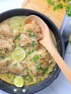 a skillet filled with chicken and limes next to a cutting board