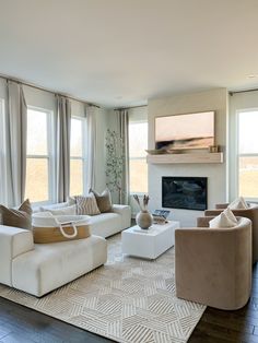 a living room filled with furniture and a flat screen tv mounted on the wall above a fireplace