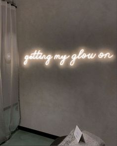 a neon sign that says getting my glow on in front of a window with curtains