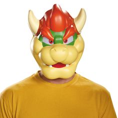 a man wearing a yellow t - shirt with a red demon mask on his face