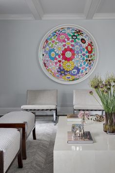 a living room filled with furniture and a large circular painting on the wall above it