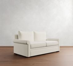 a white couch sitting on top of a wooden floor