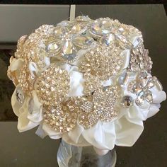 a bridal bouquet with white flowers and crystal stones on it's centerpiece