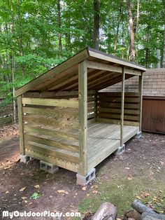 a small wooden shelter in the woods