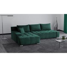 a green couch sitting on top of a carpeted floor next to a coffee table