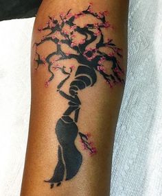 a woman with a tree tattoo on her arm is holding onto a flowered branch