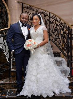 a bride and groom posing for a photo on the stairs