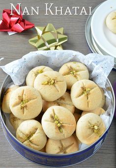 there are many small cookies in a bowl on the table with ribbons and plates behind them