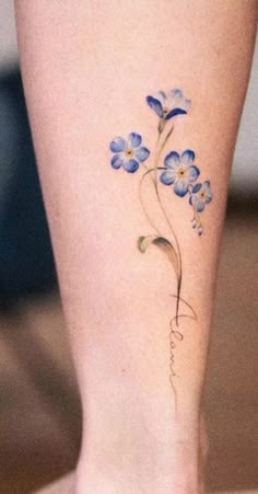 a woman's foot with blue flowers on her left side and the word love written in cursive writing