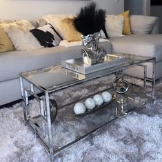 a living room with a couch, coffee table and two balls on the floor in front of it