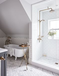 a bathroom with white tile and gold fixtures