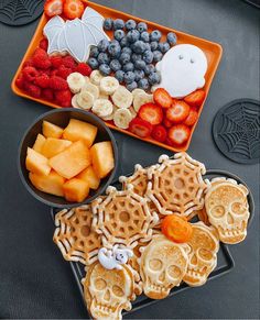 a tray filled with waffles, fruit and cookies