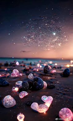 many glowing rocks on the beach with stars in the sky