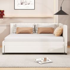 a living room with a white couch and brown pillows