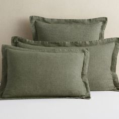 three green pillows sitting on top of a bed