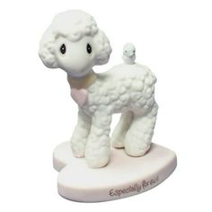 a small white sheep figurine with a baby lamb on it's back