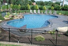 a large swimming pool surrounded by lush green trees