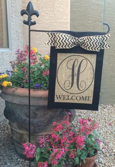 a potted planter with flowers and a welcome sign