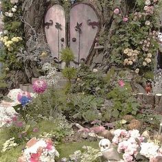 there is a garden with flowers and an old door in the middle that has been decorated