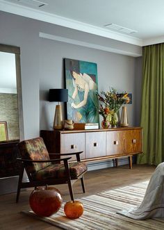 a bedroom with green drapes and paintings on the wall