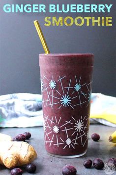 a smoothie in a cup with blueberries on the side