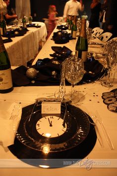 the table is set with wine glasses, plates and silverware for an elegant dinner