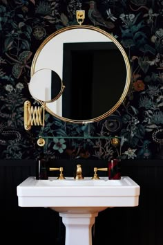 a white sink sitting under a mirror next to a wall mounted faucet in a bathroom