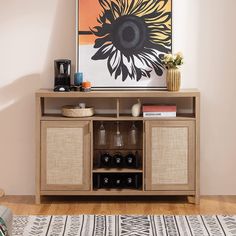 a wooden cabinet with wine bottles on it in front of a large painting and rug