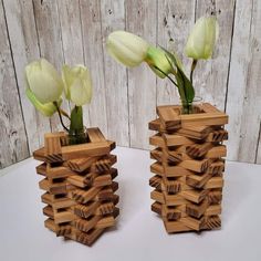 two wooden vases with flowers in them