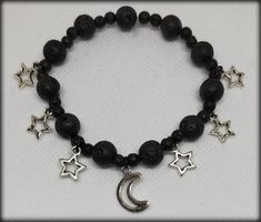 Beaded bracelet with small and large black lava stone beads, as well as silver-colored pendants in the shape of moon and stars. The beads were threaded onto an elastic cord, so the bracelet can still be stretched. (It is costume jewelry.) Whimsigoth Bracelet, Black Bracelet Ideas, Moon Beaded Bracelet, Moon Clothes, Accesorios Aesthetic, Diy Seed Bead Earrings, Bracelets Black, Elastic Bracelets, Crystal Bead Jewelry