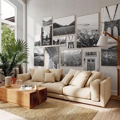 a living room with lots of pictures on the wall and a coffee table in front of it