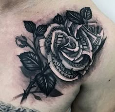 a black and white rose tattoo on the chest