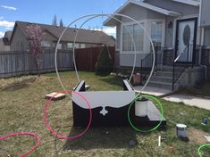 an upside down bed sitting in the middle of a yard next to a fence and house