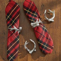 two pieces of red and black plaid fabric tied to silver rings on a wooden surface