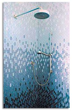 the shower head is mounted to the side of the wall with mosaic tiles on it