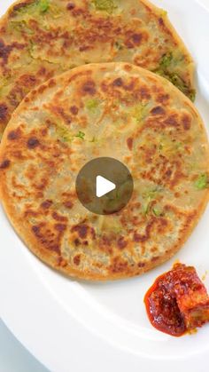 two flatbreads on a white plate with ketchup next to each other