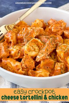 a white bowl filled with cheese tortellini and chicken sauce next to a fork