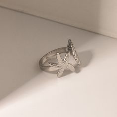 Embrace the spirit of summer with our Adjustable Stainless Steel Bohemian Beach Ring. Crafted to capture the essence of beachside freedom and boho chic, this ring features a unique, irregular design adorned with starfish and shell motifs. Perfect for beach parties, vacations, or just adding a touch of seaside magic to your everyday wear, this ring brings the ocean’s charm right to your fingertips. Product Features The Bohemian Beach Ring is designed with versatility and durability in mind. Its a Starfish Jewelry For Vacation, Summer Beach Midi Rings, Beachy Starfish Jewelry For Vacation, Summer Beach Metal Jewelry, Beach Toe Ring Jewelry, Beach Summer Jewelry Ring, Summer Beach Jewelry Ring, Adjustable Metal Ring Jewelry For Summer, Summer Beach Ring Jewelry