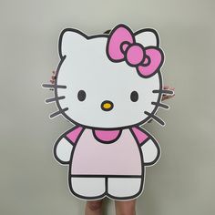 a hello kitty cardboard cutout is standing in front of a wall with her hands on her hips