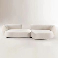 two white couches sitting next to each other on a white floor in front of a wall