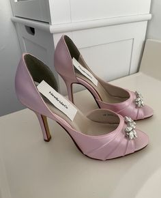 a pair of pink high heeled shoes sitting on top of a white countertop