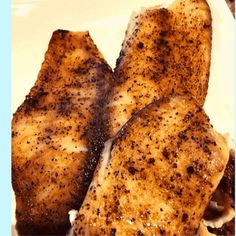 two pieces of chicken sitting on top of a white plate