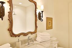 a bathroom with two sinks, mirror and towels on the counter top in front of it