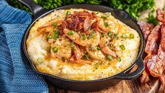 a cast iron skillet with shrimp and grits in it