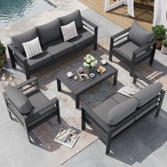 an outdoor living room with grey couches and coffee table next to swimming pool area