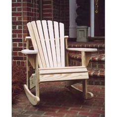 a wooden rocking chair sitting in front of a brick building