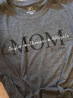 a gray shirt with the word mom on it and an image of a cat laying next to it