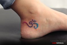 a small tattoo on the foot of a person with an omen symbol painted on it